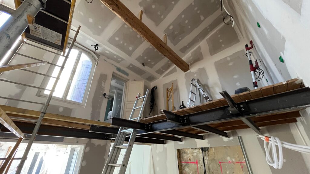 Travaux de rénovation intérieure avec échafaudage et échelles.